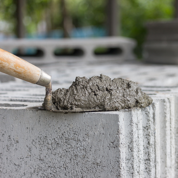 Bricklayer's trowel with mortar lies on stacked hollow concrete blocks Bricklayer's trowel with mortar lies on stacked hollow concrete blocks